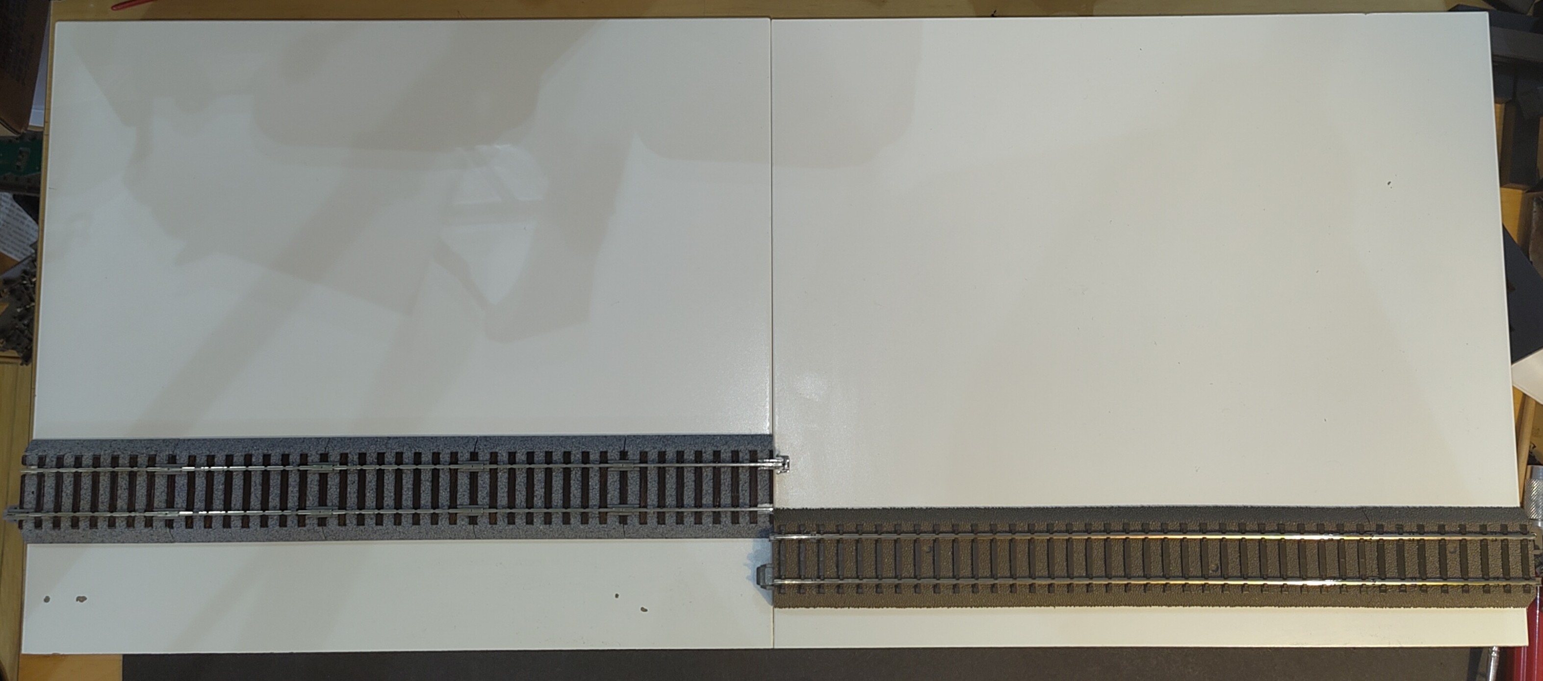 Two IKEA LACK 300mm baseboards, one with KATO UniTrack spaced 42mm from the edge and one with TRIX C-Track spaced 15mm from the edge.
